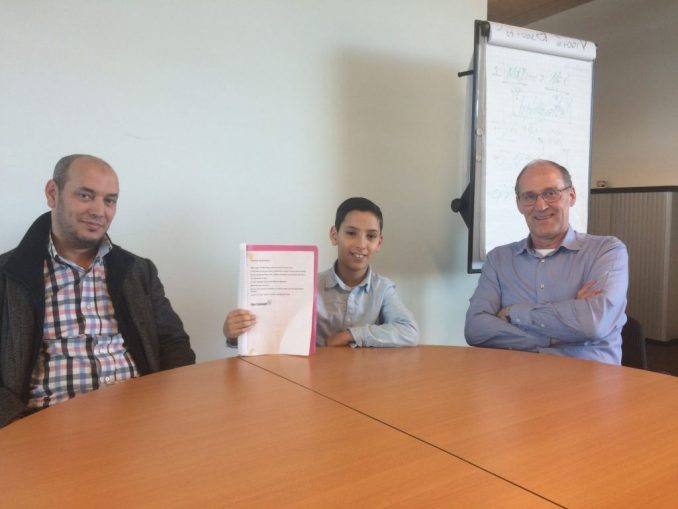Bilal met zijn brief, zijn vader (links) en Cees Admiraal (rechts)