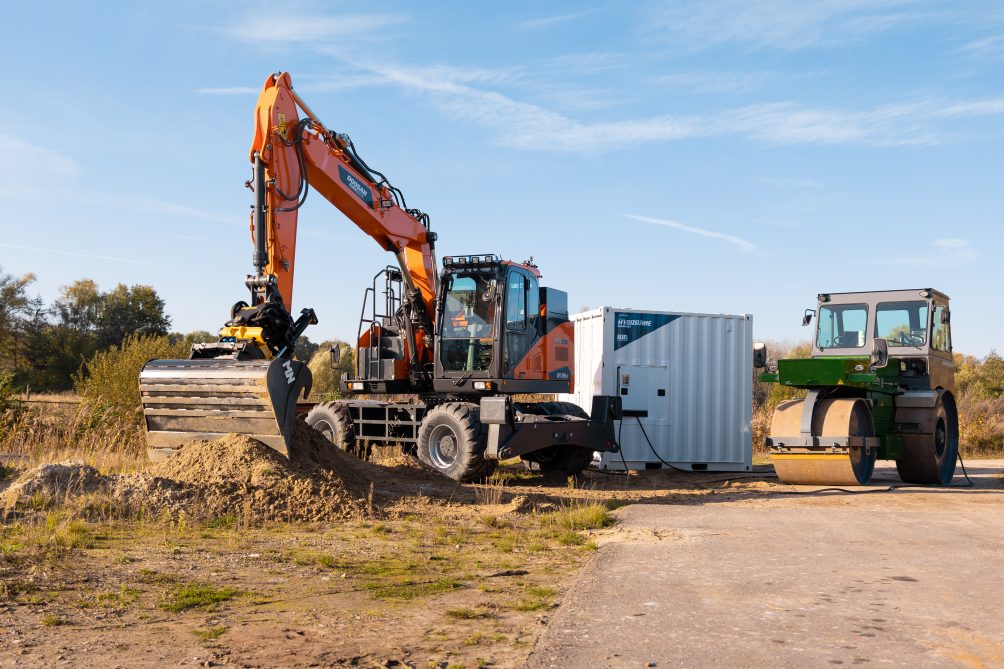 Orange excavator digging up dirt