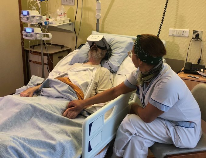 Vrouw bij bed man met VR-bril op